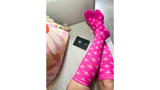 Compression socks on legs next to Australian passport