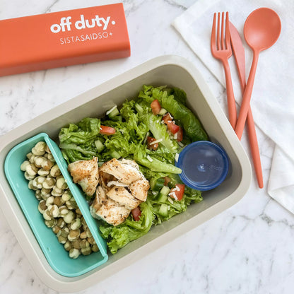 Reusable cutlery set in orange with chicken salad.